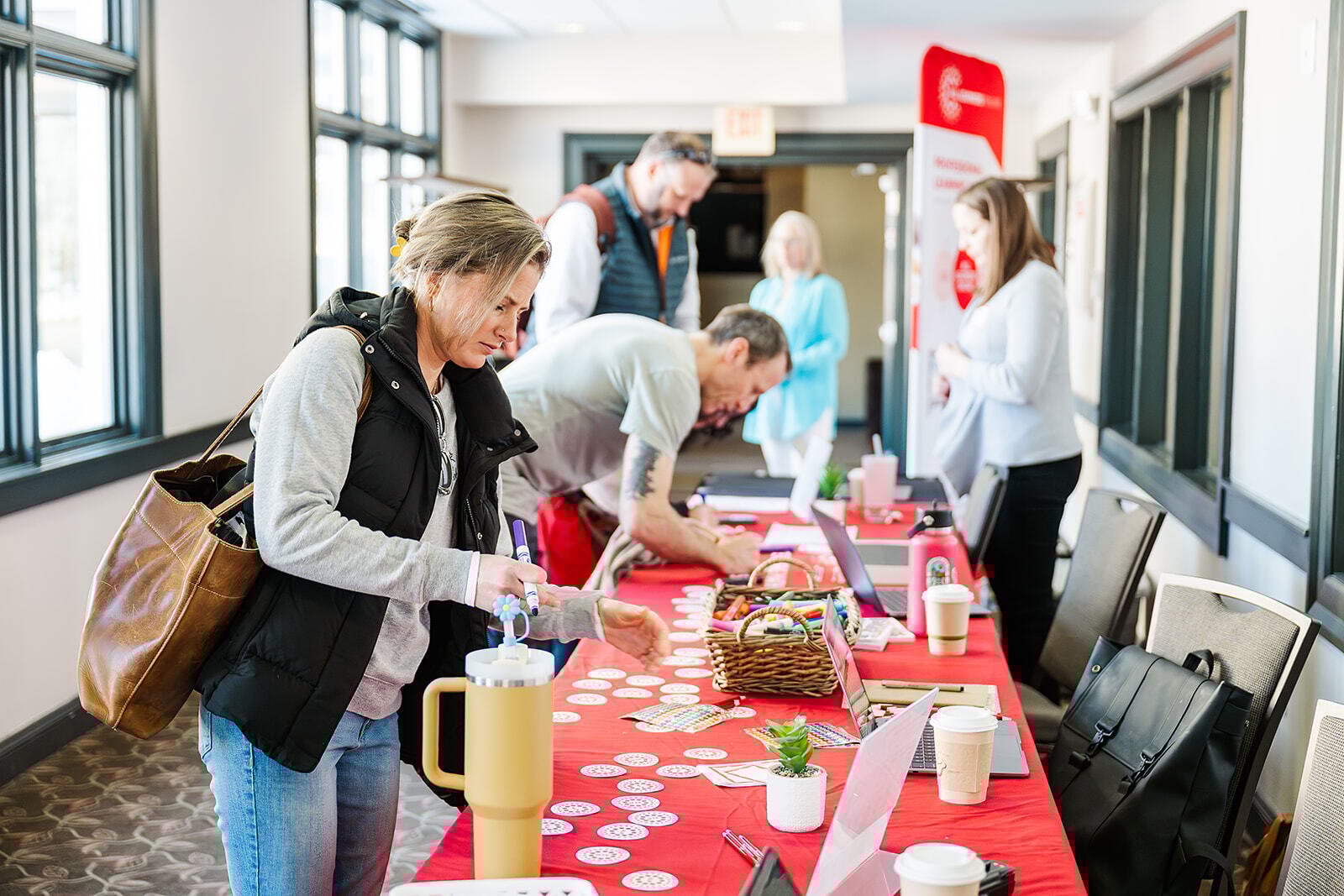 Attendees at a conference look at materials on an information table